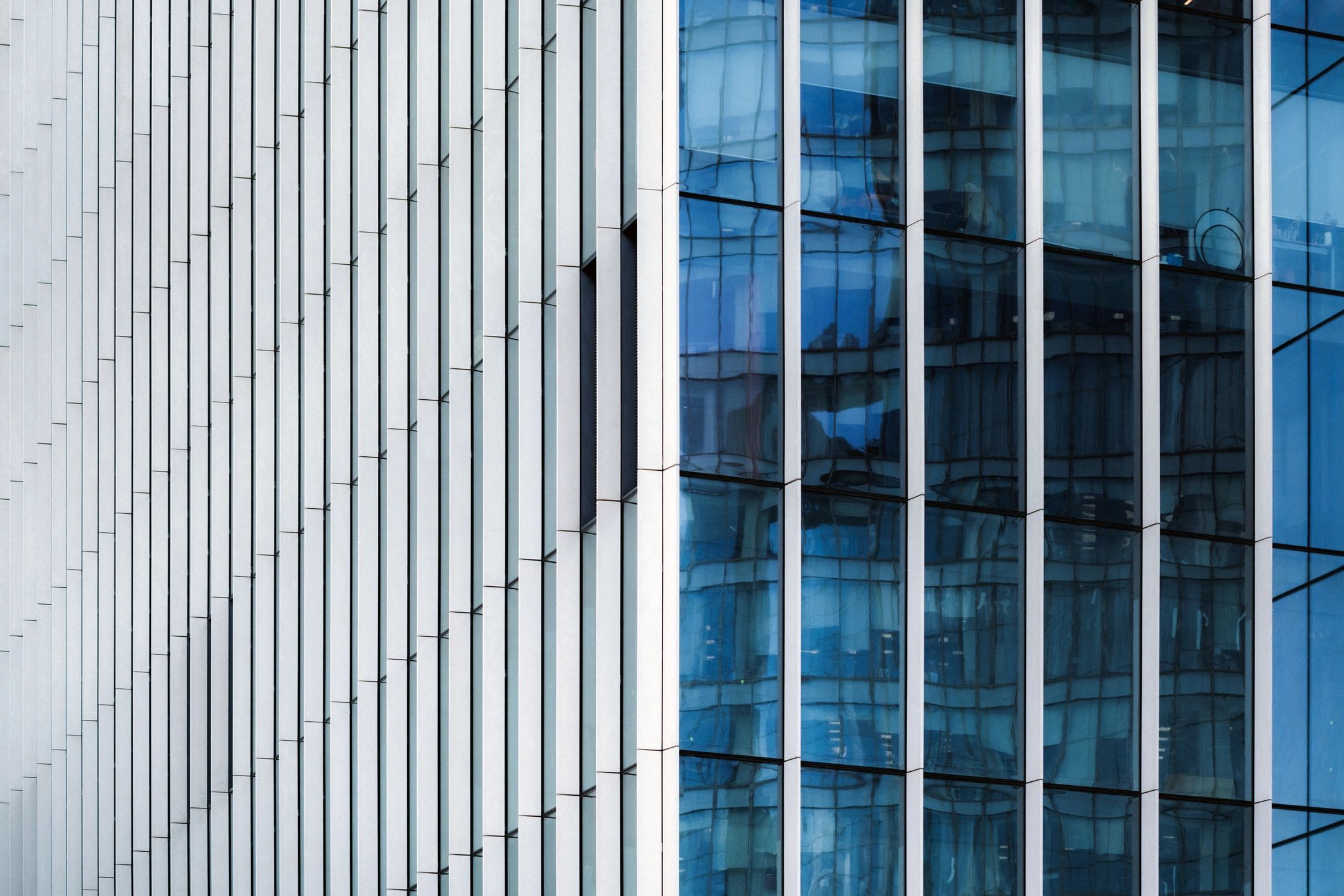 Modern office exterior facade close-up reflecting buildings and environment and forming unique complex pattern