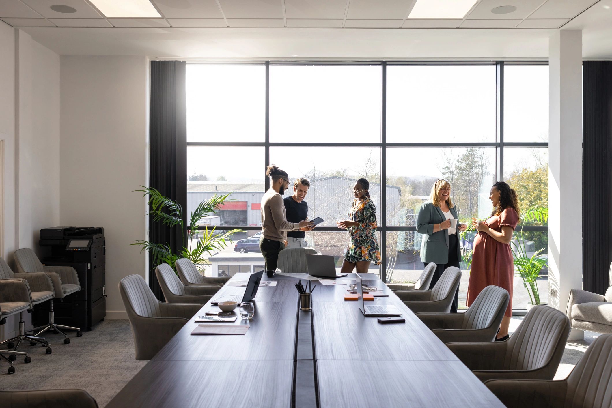 Executive team in a modern boardroom discussing strategy in a refined corporate setting